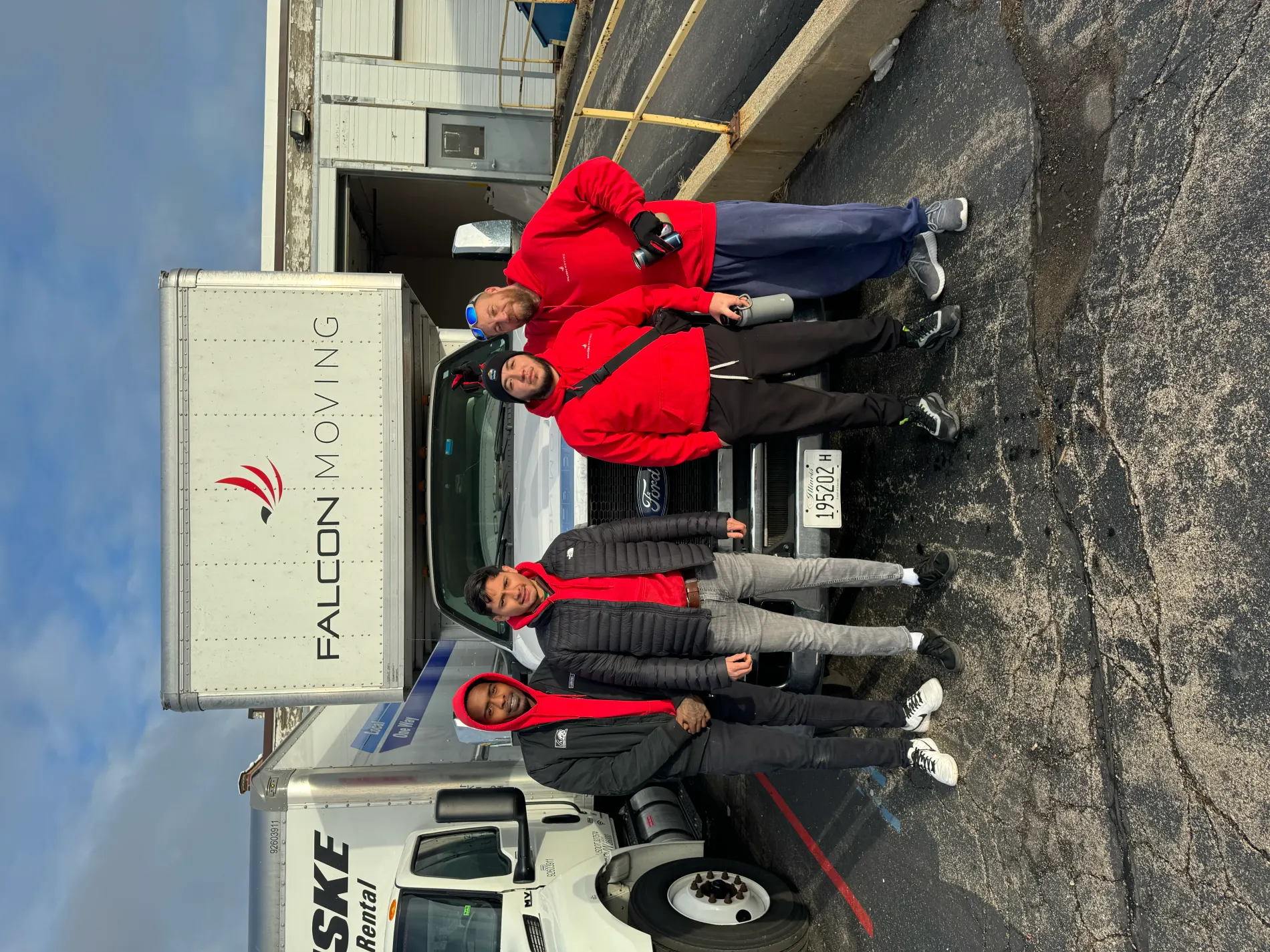 Falcon Moving crew staged beside a branded truck before a route