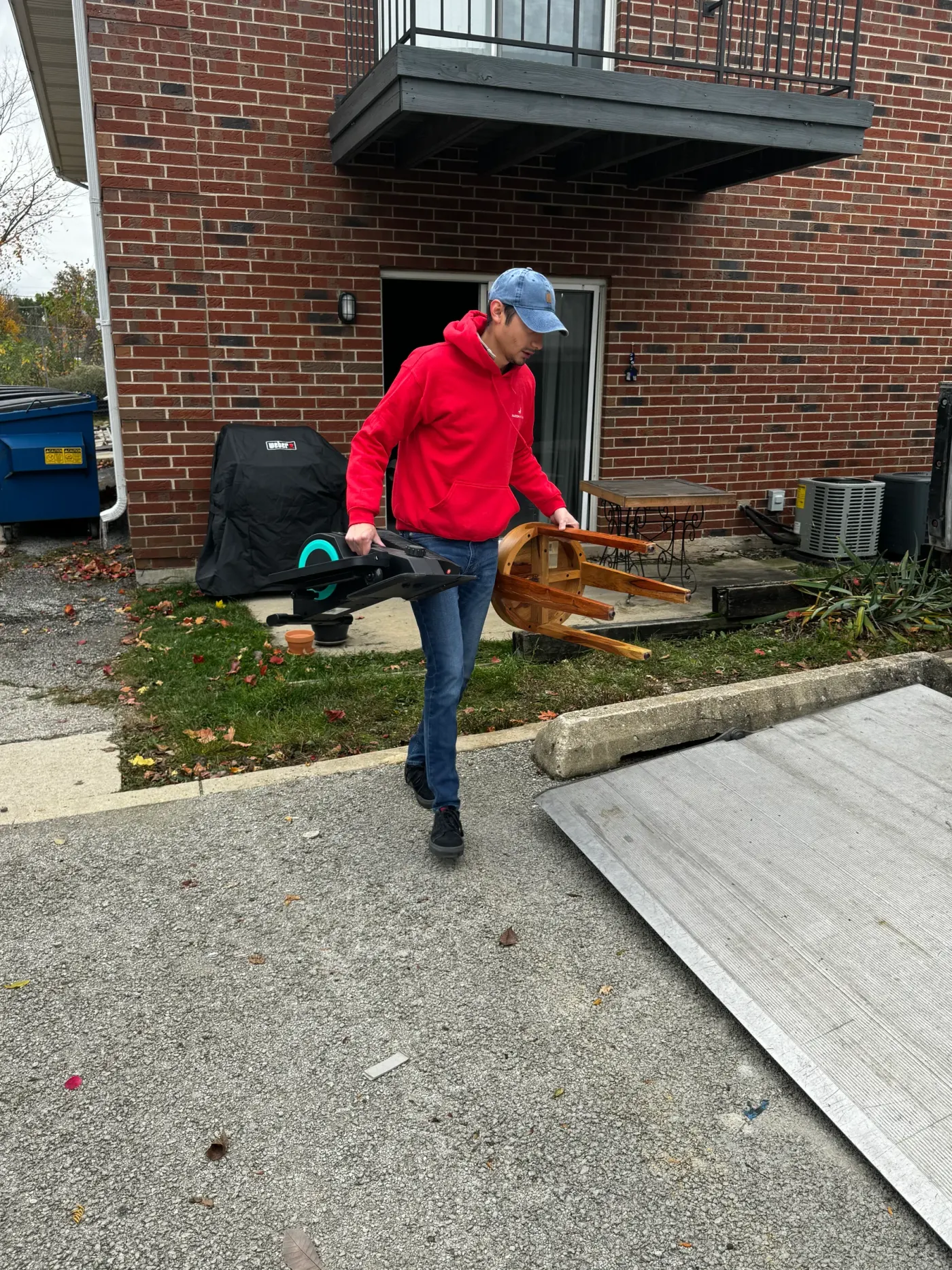 Falcon Moving junk removal crew carrying unwanted items outside a home